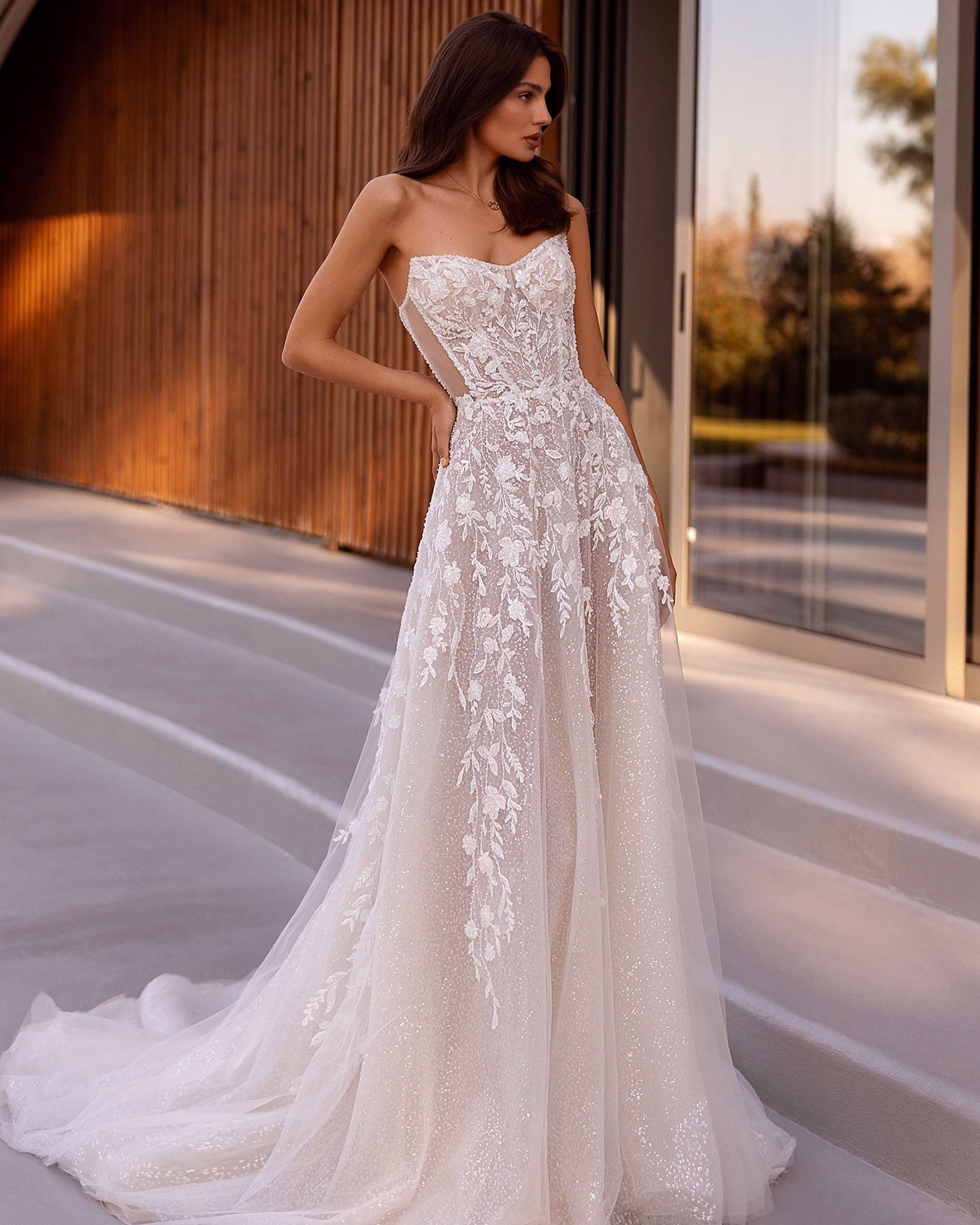 Demetrios Style 1501 beaded lace A-line wedding dress with a strapless sweetheart neckline, sheer corset bodice, exposed boning, transparent back, sparkling tulle, and elegant train.