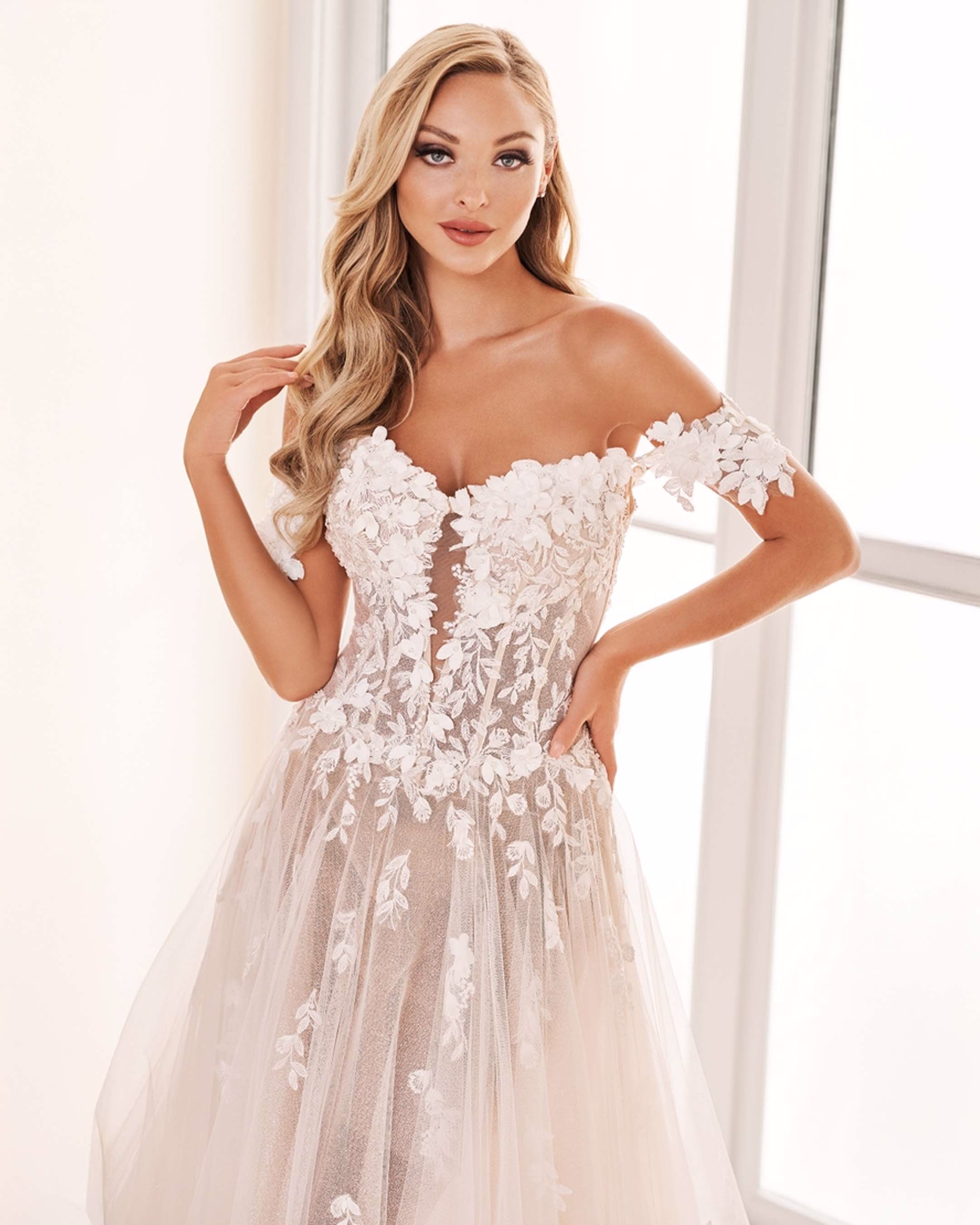 Enchanting by Mon Cheri E2528 A-line wedding dress featuring 3D floral lace appliqué, sparkle illusion, off-the-shoulder sweetheart neckline, and cathedral train.