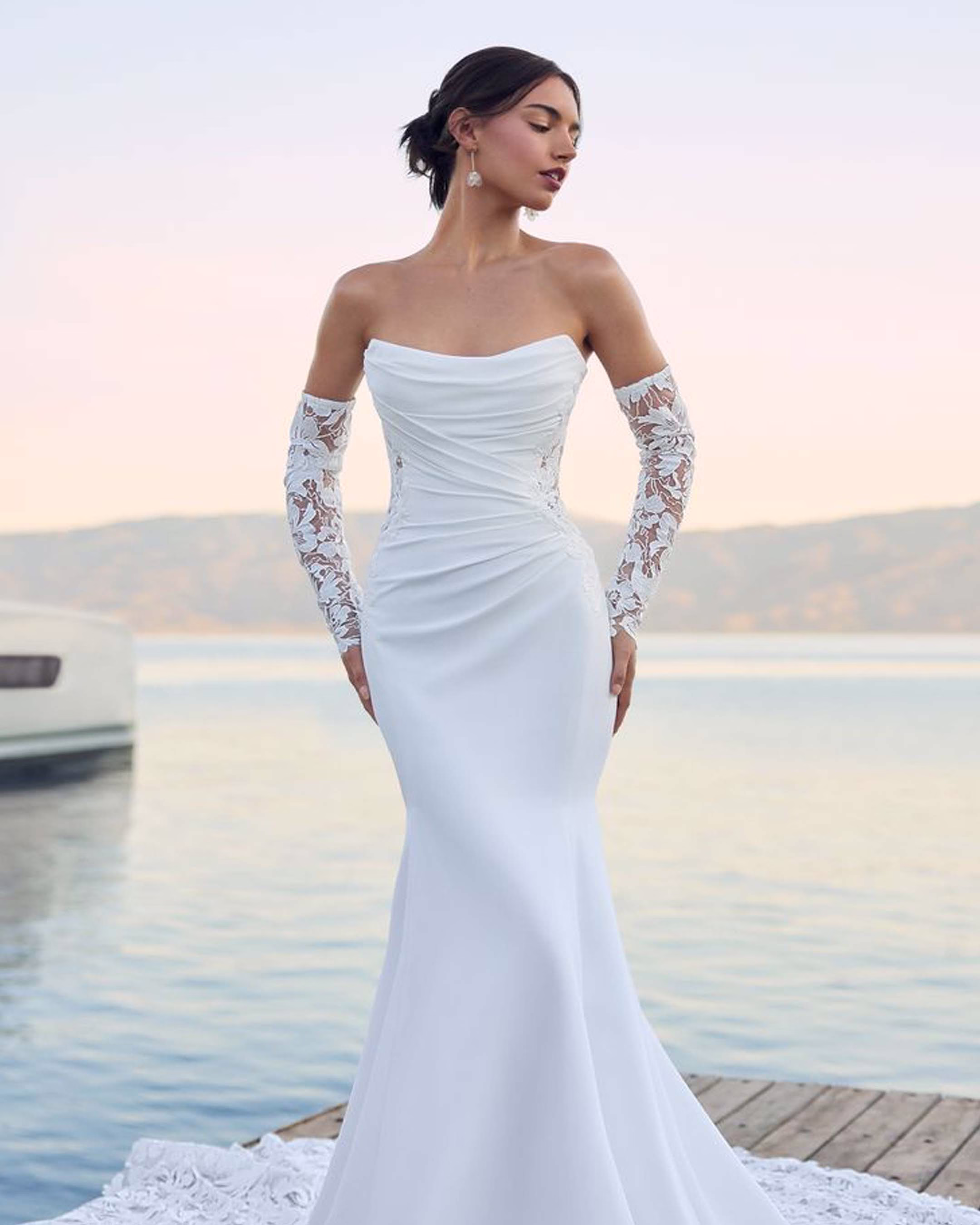 Sophia Tolli Lucie Y3180 crepe fit-and-flare wedding dress with soft scoop neckline, detachable off-the-shoulder gauntlet sleeves, illusion lace back, and dramatic laser-cut train.