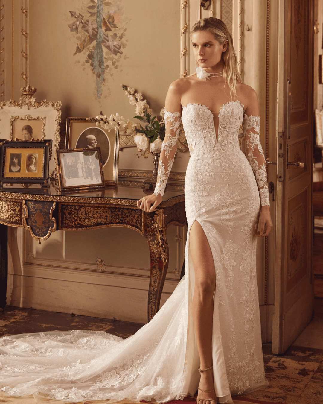 Demetrios Style 1306 lace and tulle wedding dress with deep V-neckline, strapless bodice, thigh-high slit, flowing skirt, and optional long sleeves.