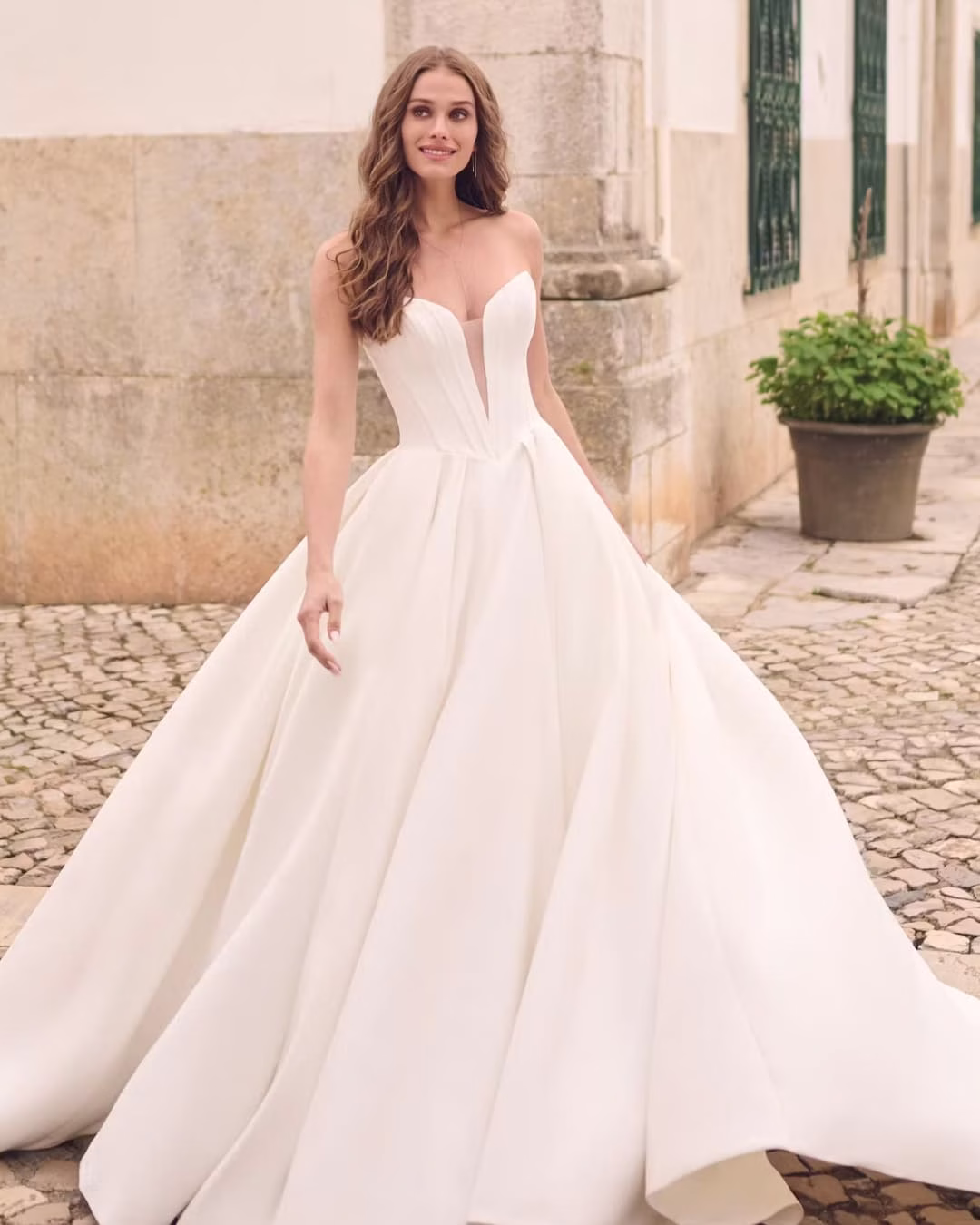 Maggie Sottero Derrick ball gown wedding dress featuring a romantic silhouette, elegant bodice details, full skirt, and dramatic bridal train.