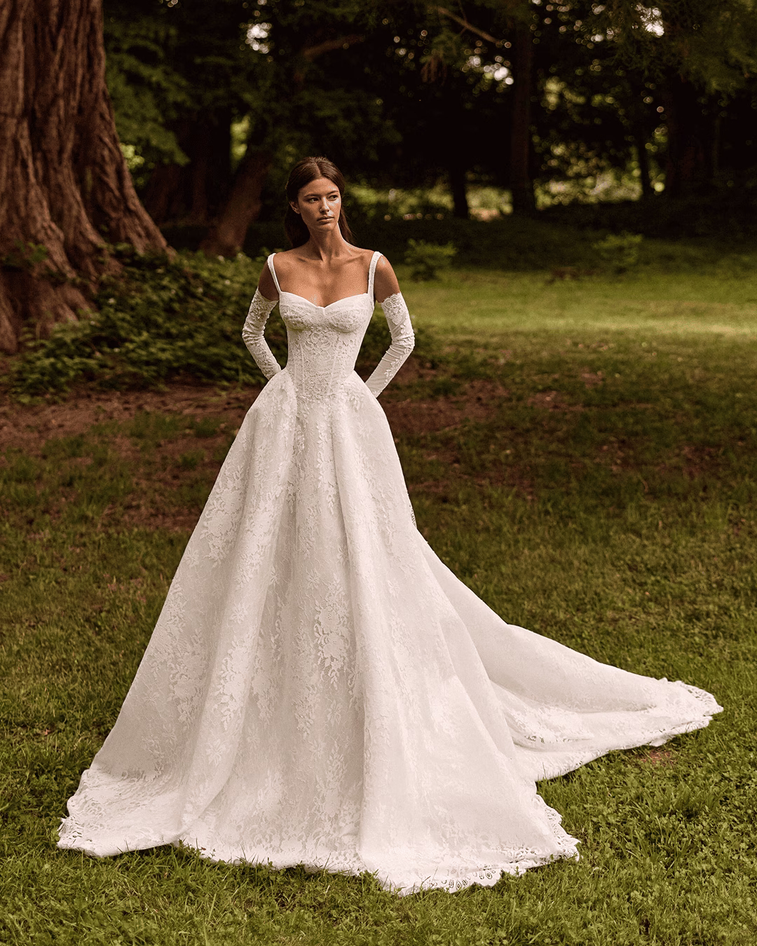 Milla Nova Elisora lace A-line wedding dress with a structured corset bodice, romantic neckline, flowing skirt, and elegant train.