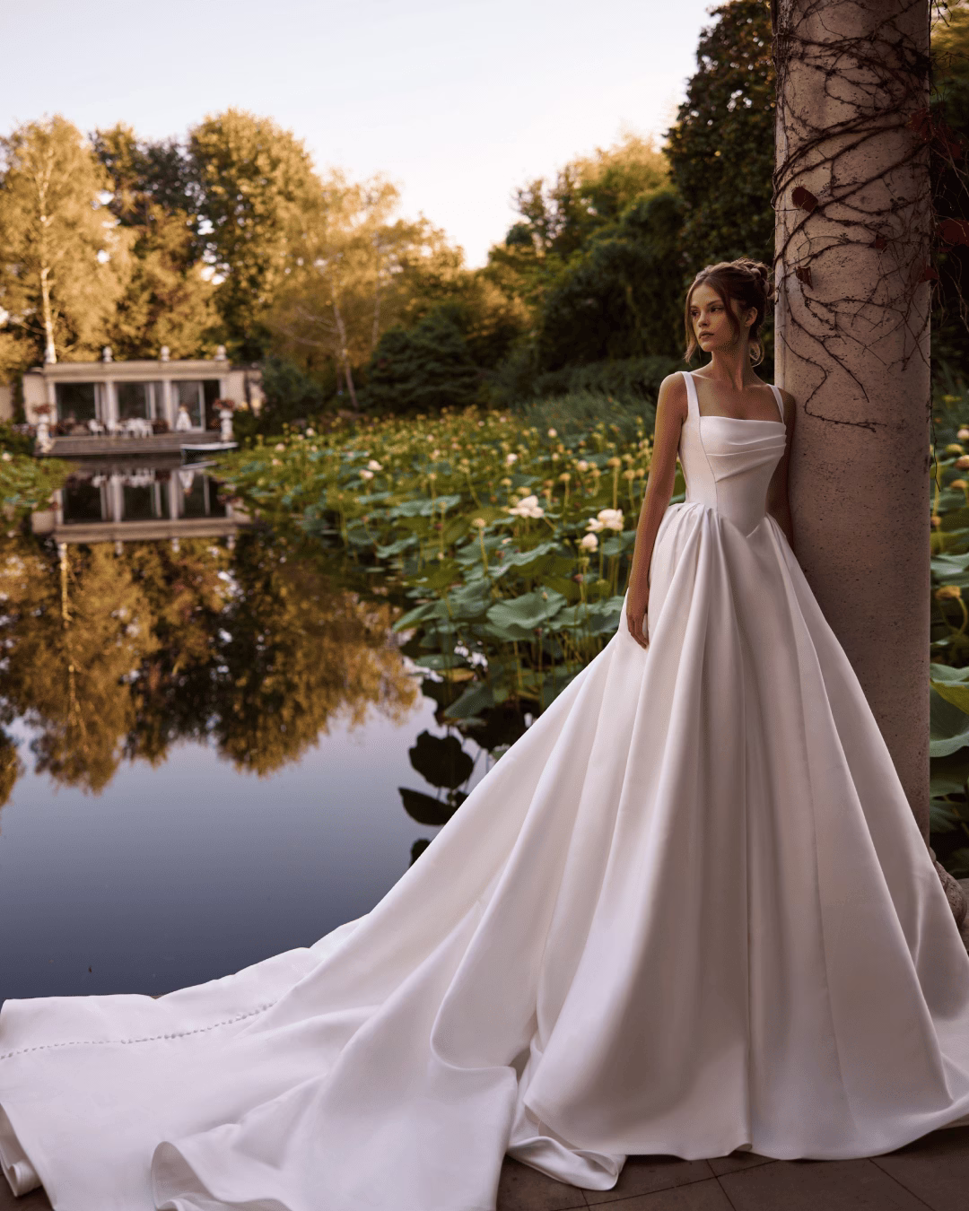 Milla Nova Ermana lace A-line wedding dress with a structured corset bodice, delicate lace details, romantic neckline, and flowing train.