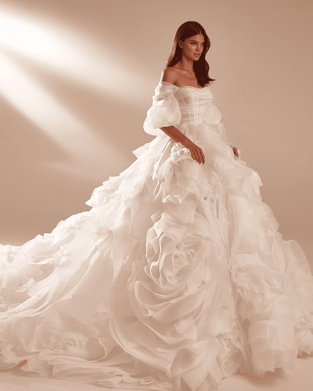 Milla Nova Florina organza princess wedding dress with off-the-shoulder puff sleeves, draped corset bodice, voluminous ruffle skirt, and an extra-long train.