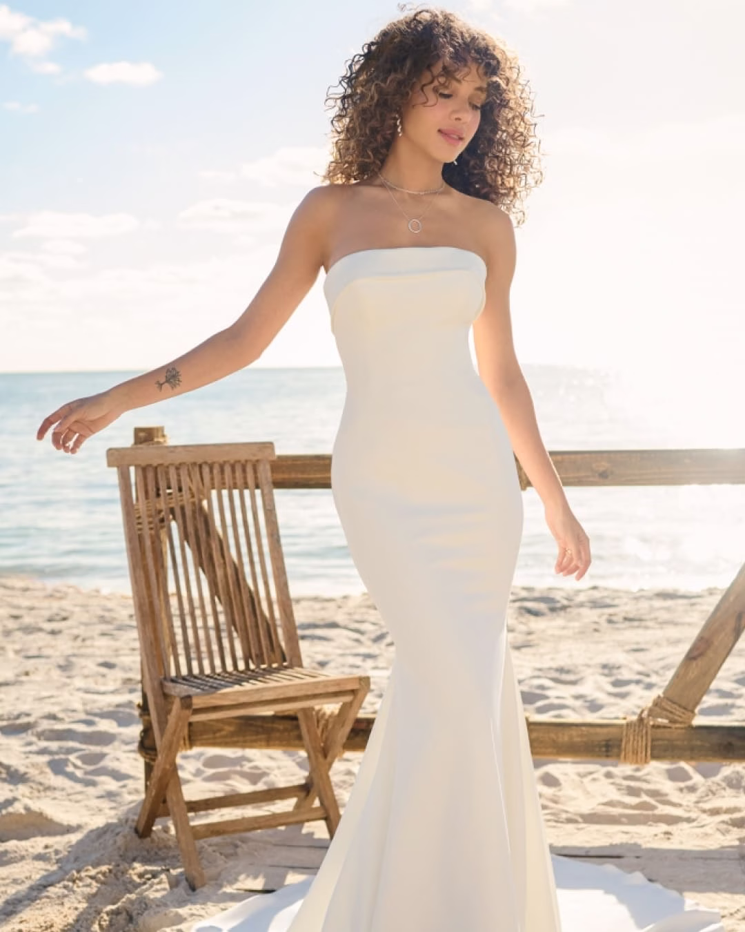 Rebecca Ingram Francine sheath wedding dress featuring a straight neckline, strapless banded cuff, stretch crepe fabric, and elegant sweep train.