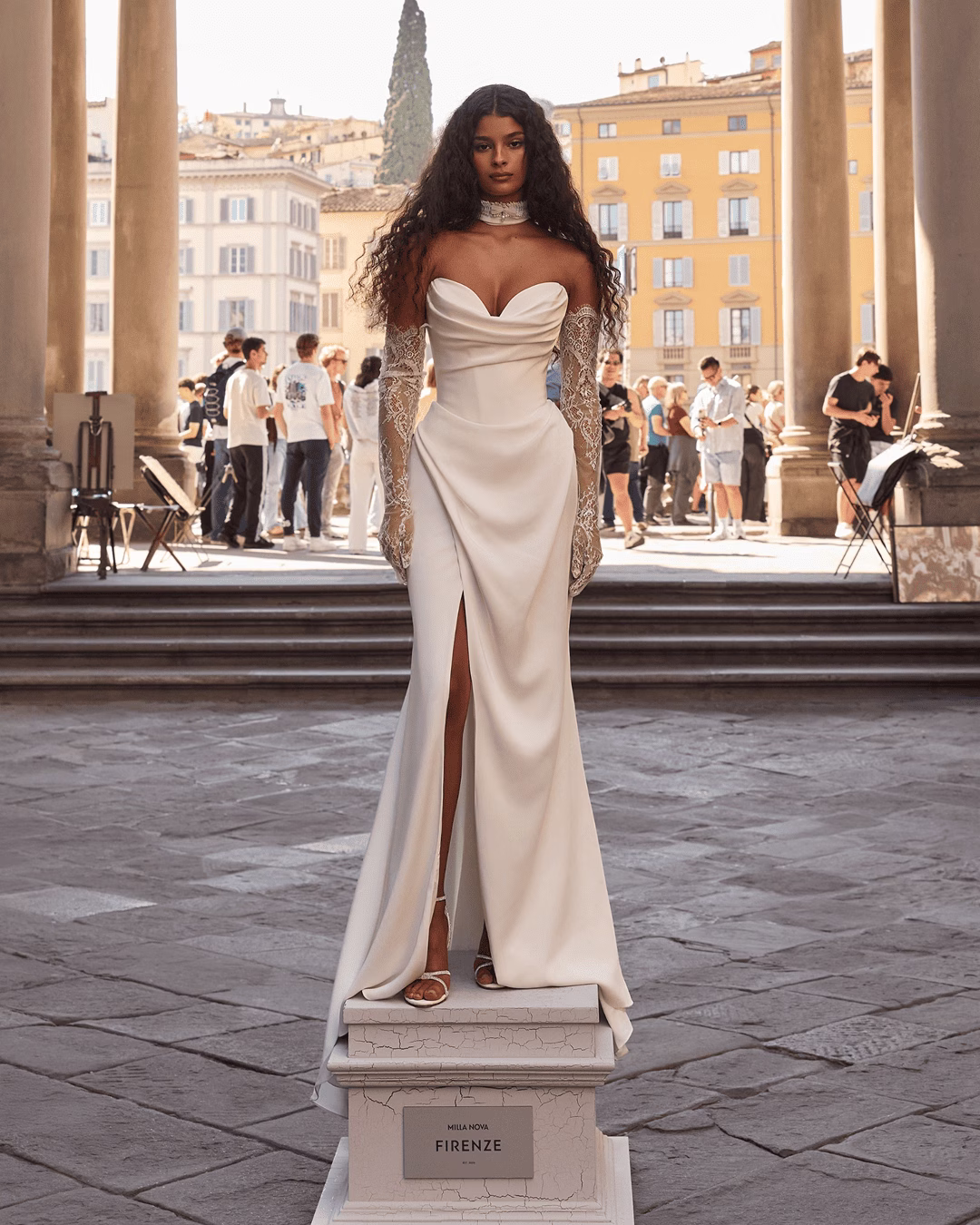 Milla Nova Odyssia Italian satin mermaid wedding dress with a sculpted draped bodice, detachable off-the-shoulder straps, fitted silhouette, and softly flared skirt.