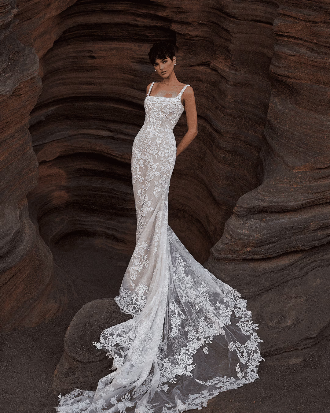 Milla Nova Theodora glitter lace mermaid wedding dress with floral lace ornaments, square neckline, thin straps, fitted skirt, nude lining, and midi train.bodice, romantic silhouette, and elegant bridal detailing.